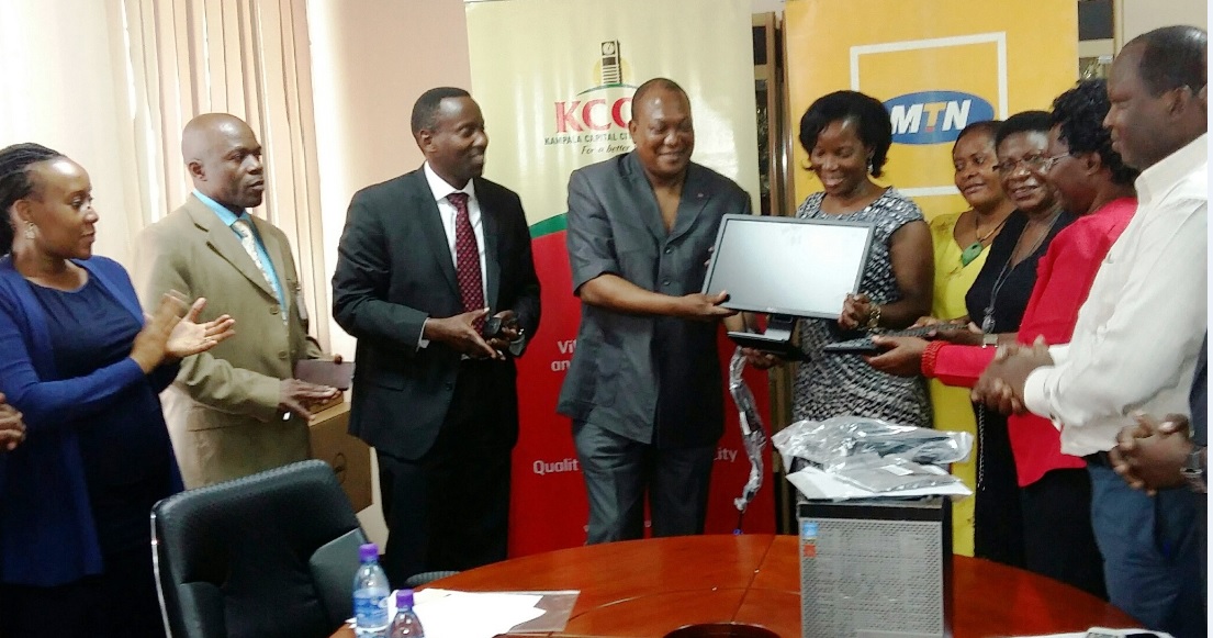 South African High Commissioner to Uganda Prof. Maj. Gen. (Rtd) L. S. Mollo, also trustee member of MTN Foundation hands over computer to Ms. Jennifer Musisi as MTN's Geneal Manager Corporate Services Anthony Katamba looks on.
