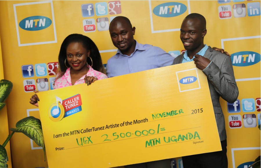 MTN’s Brand Manager Isaac Tegule (Center ) hands over a dummy check of Ugx 2.5M to Chris Evans (Right ) and Rema Namakula (Left) for winning as artists of November in the MTN CRBT Online awards with their duet “Linda”