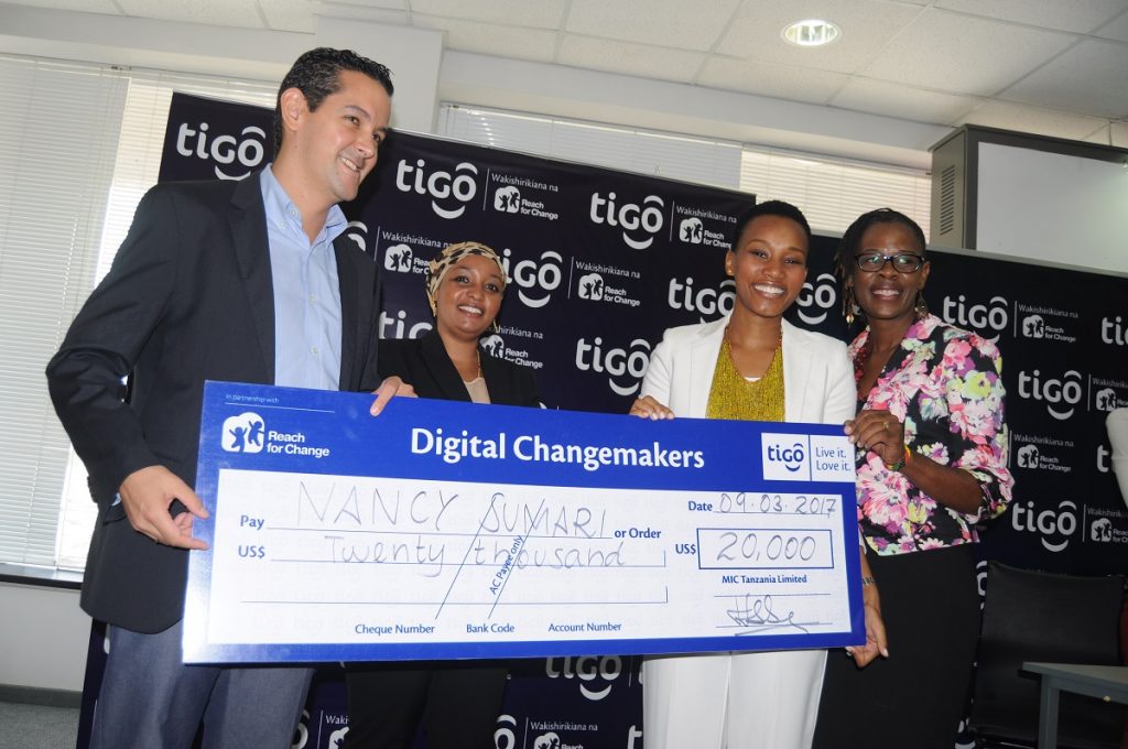 Tigo Tanzania Managing Director, Diego Gutierrez (right), hands over a dummy cheque to Nancy Sumari, (right, in white), one of the winners of the Tigo Digital Change-makers’ awards in Dar es Salaam last Thursday. Looking on are, Tigo Corporate Social Responsibility Manager, Halima Okash, (center) and Reach for Change Country Manager, Josephine Msambichaka (Photo Courtesy: Tigo)