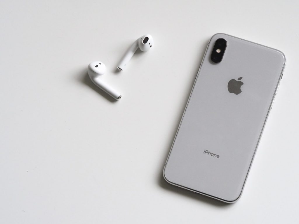 A Pair of Apple's AirPods pictured next to an iPhone. (Photo by Plush Design Studio from Pexels)
