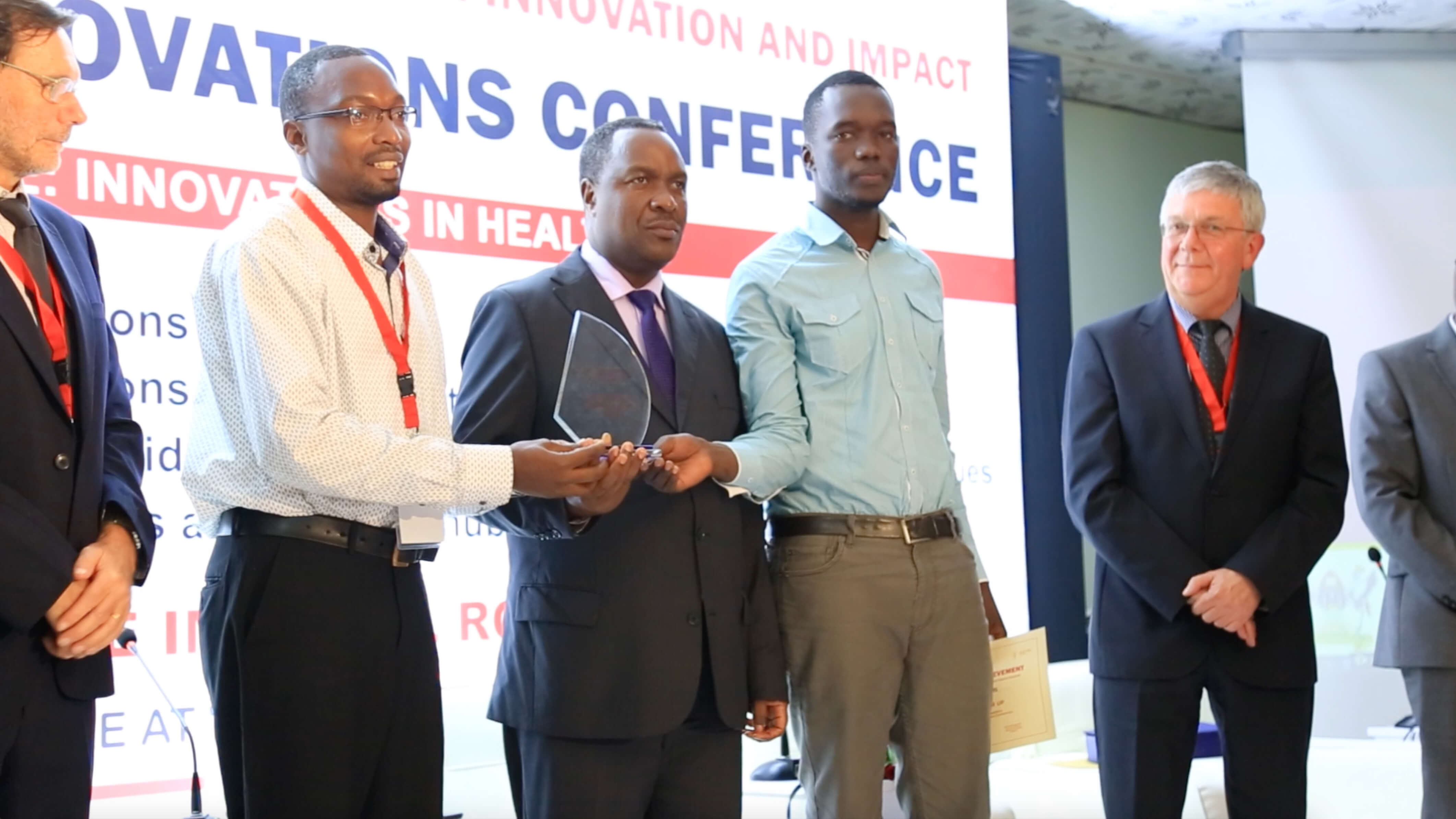 Hon. Elioda Tumwesigye, Minister of Science Technology and Innovation (center) giving out an award to one of the winners at the first Health Innovation Conference in March 2018 | File Photo/UAHII.
