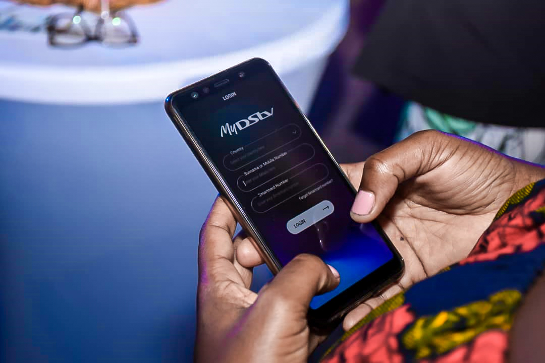MultiChoice Uganda Head of Customer Experience, Ms. Patrica Kiconco demostrates how the MyDSTV app works after the launch of the apps at their head offices in Kololo on Thursday May, 30th 2019.