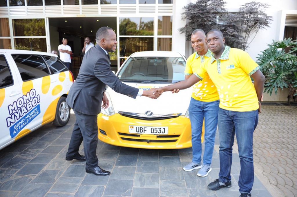Mayor of Masaka; Kayemba Afaayo shakes hands with MTN Uganda's Ag. GM Risk and Compliance Samuel Gitta as Senior Manager Manager Financial Services at MTN Uganda, Christopher Sali looks on.