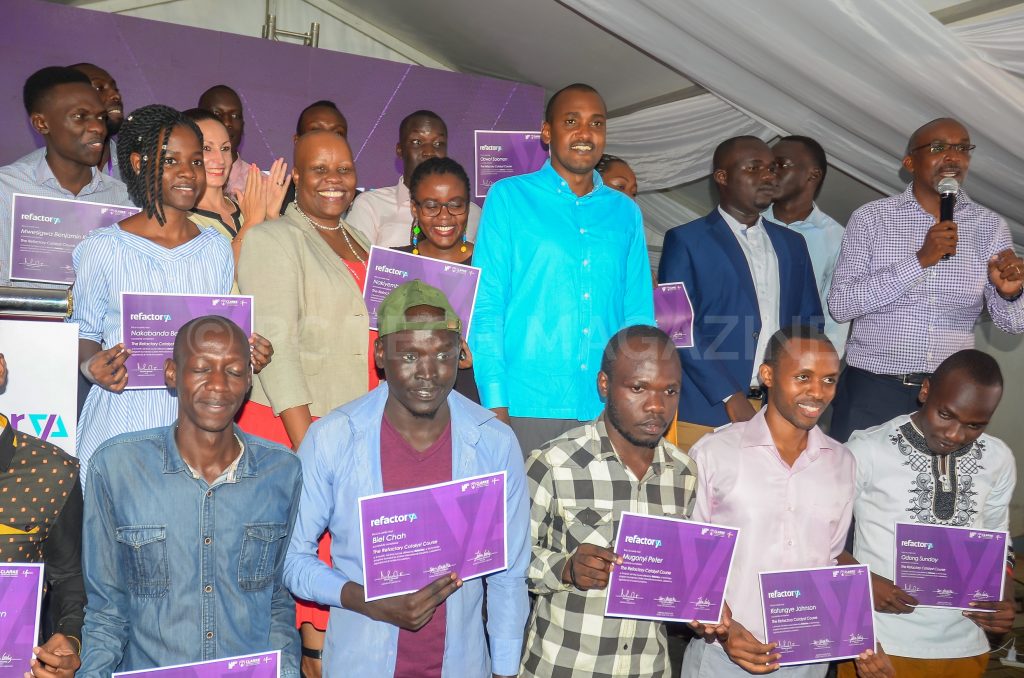 The first cohort with their certificates of completion of the caralyst program pose for a group photo with the minister and partners from Clarke International University, Laboremus, and Fontes after the Minister officially launched the Refactory Program.