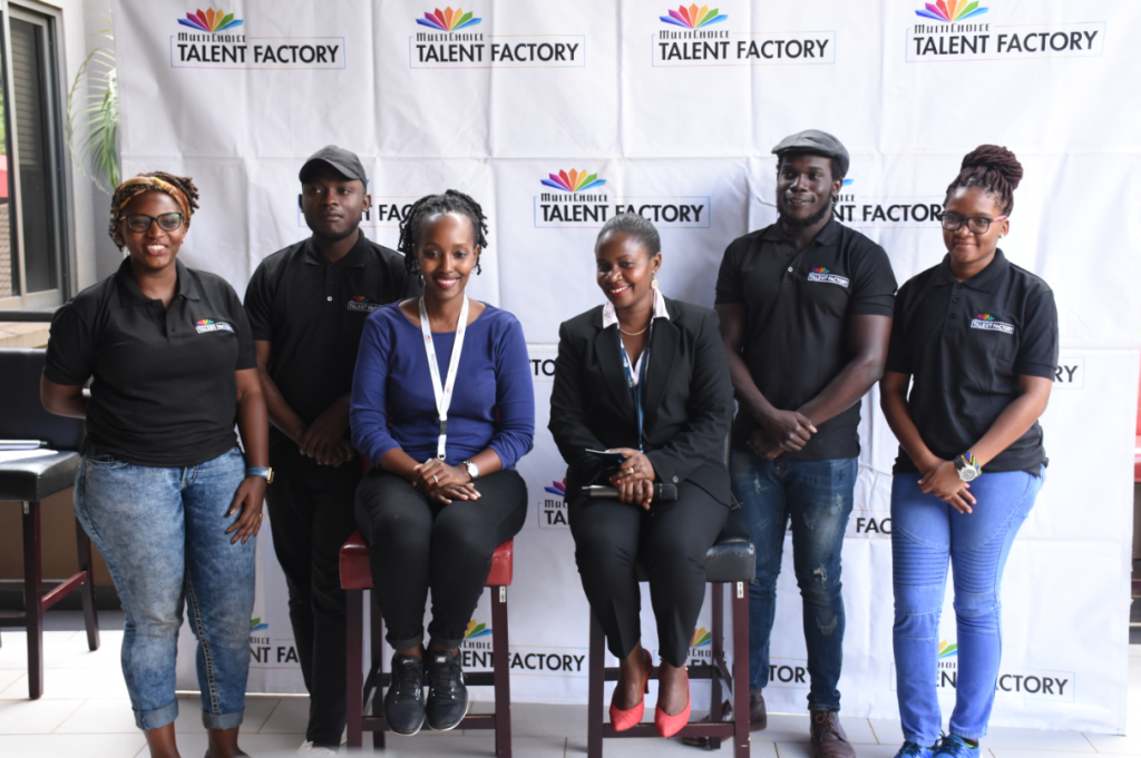 Students of MultiChoice Talent Factory (MTF) Academy Class of 2019/20 pose for a group photo with Joan Ssemanda Kizza (L) and Ruth Kibuuka (R) at their unveil at the MultiChoice Uganda head offices.