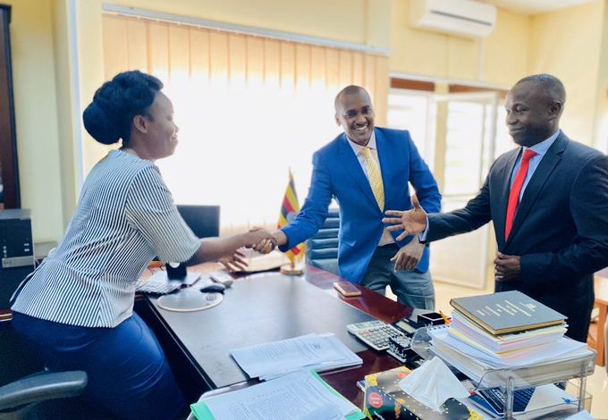 Frank Tumwebaze (blue coat) shaking hands with incoming Minister of ICT and National Guidance Judith Nabakooba (L) and State Minister of ICT Peter Ogwang (R) at Ministry head offices in Kampala. Courtesy Photo
