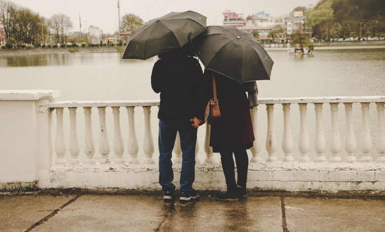A couple holding hands on a bridge. (Photo by Romnw/Unsplash)