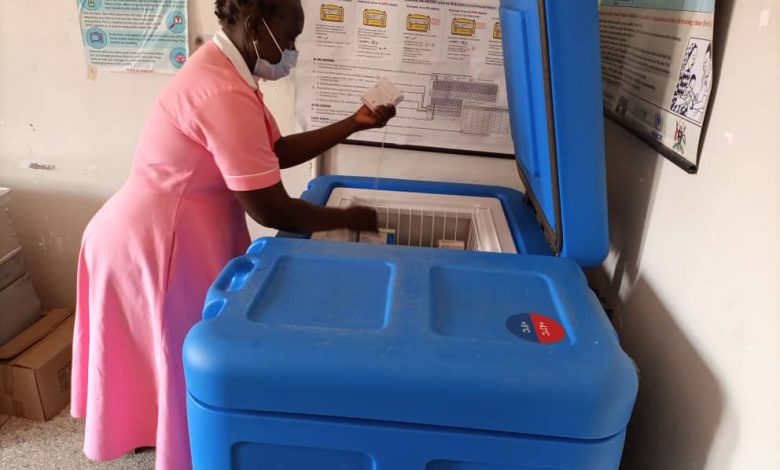 A nurse at Bidibidi Health Centre III checks for a vaccine in the solar-powered fridge that was donated to the health center by MTN Foundation in partnership with UNHCR. (COURTESY PHOTO)