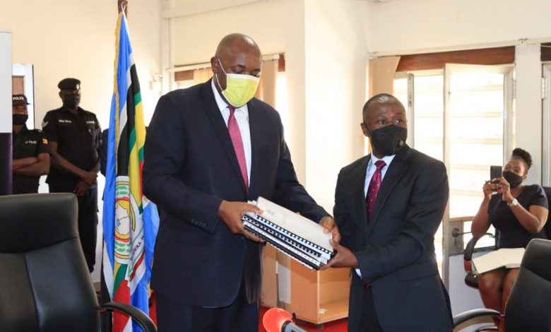 Former State Minister of ICT and National Guidance, Hon. Peter Ogwang (left) hands over office to incoming Minister of ICT, Hon. Chris Baryomunsi (right) at the Ministry's head offices in Kampala. (PHOTO: ICT Ministry)