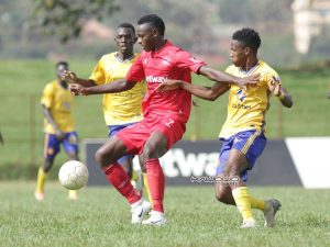 Eric Kambale (center) shields Ashraf Mugume off the ball as Bright Anukani closes in. (PHOTO: John Batanudde/Kawowo Sports)