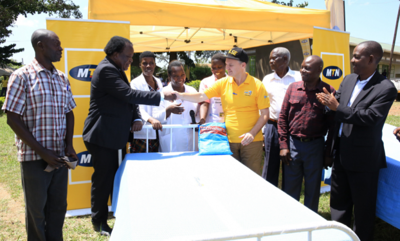 MTN Foundation led by MTN Uganda CEO Mr. Wim Vanhelleputte (yellow t-shirt and cap) handing over beds, mattresses, bedsheets and mosquito nets to Dr. Jonathan Wangisi. (FILE PHOTO)