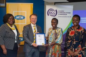 MTN Uganda CEO, Wim Vanelleputte (2nd from left) receiving the telco’s ‘Second National Telecommunication Operator Licence’ from UCC Executive Director, Irene Kagawa Ssewakambo. (FILE PHOTO)