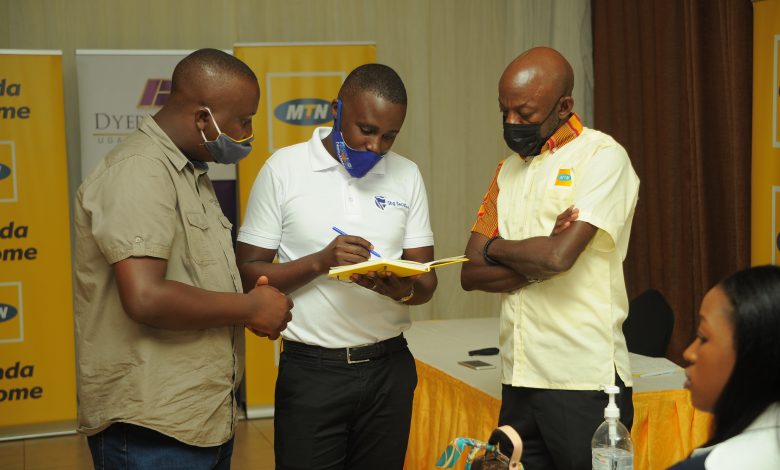 Michael Kawesa Sekadde (extreme right), MTN Uganda General Manager Human Resources along with a licensed broker from Crested Capital attend to a member of the public during the Masaka IPO Town hall meeting to drive awareness about the MTN IPO.