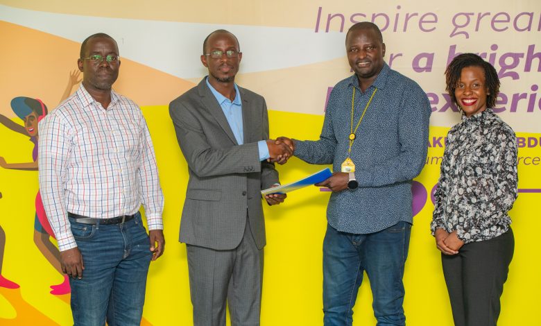 JUMO's Country Manager, Wilfred Wabwire (2L) shakes hands with MTN MoMo Uganda's Managing Director, Richard Yego (3L) upon launching MoSente at the MTN MoMo Uganda Offices in Kololo.