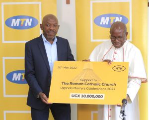 MTN Uganda’s General Manager for Human Resources, Mr. Michael Ssekadde (left) handing over the UGX10 million cheque to Msgr. Charles Kasibante for the preparation of of Martyrs Day Celebrations.