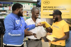 Derrick Juuko (c) a pharmacist at Ecopharm pharmacy is a happy to be an MTN Business Internet customer.