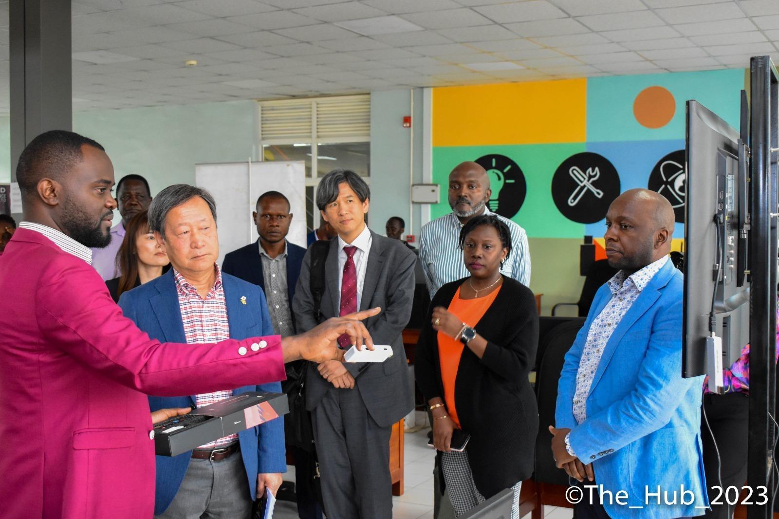 Executive Vice President of the Japan International Cooperation Agency (JICA), Dr. Junichi Yamada (center) and Cente-Tech CTO, Peter Kahiigi (right) interact with an ICT innovator.