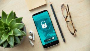 A smartphone with a shield overlay, highlighting mobile security. PHOTO: Dan Nelson/Unsplash
