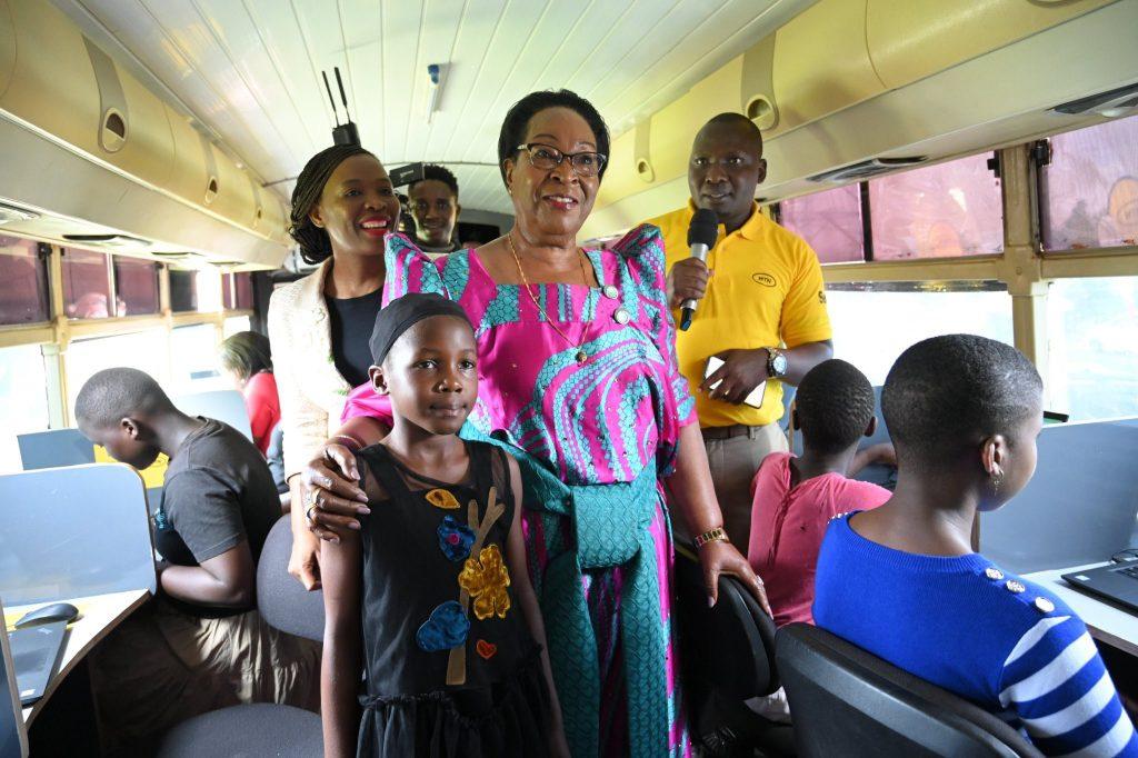 Hon. Joyce Nabbosa Ssebugwawoa, the State Minister for ICT with a group of learners pictured inside an MTN ICT bus during the launch of the MTN Skills Academy.