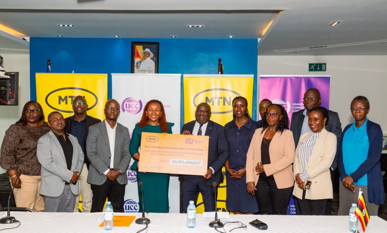 MTN Uganda CEO Ms. Sylvia Mulinge (5th from left) hands over a dummy cheque of UGX42.5 billion to UCC's Executive Director Thembo Nyombi. The contribution will goes towards developing telecommunications services in underserved areas.