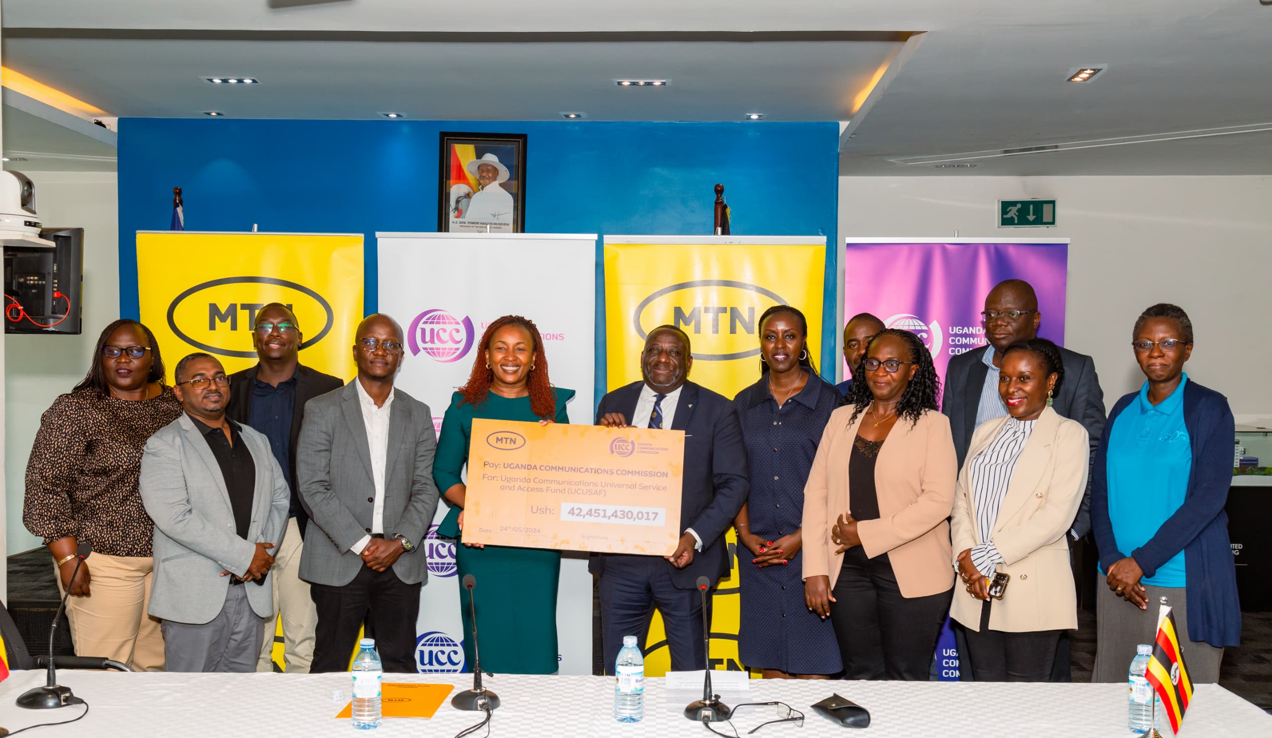 MTN Uganda CEO Ms. Sylvia Mulinge (5th from left) hands over a dummy cheque of UGX42.5 billion to UCC's Executive Director Thembo Nyombi. The contribution will goes towards developing telecommunications services in underserved areas.