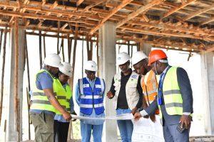 L-R: Centenary Technology Services’s Chief Technology Officer Peter Kahiigi, Centenary Group’s Group Company Secretary & General Counsel: Brenda Magoba, Centenary Group Chairperson Prof. John Ddumba-Ssentamu and the contractors at the data centre construction site. PHOTO: Kulu Erick
