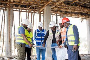 Site engineers display blue prints of the ongoing construction of Centenary Group’s state-of-the-art Tier 3 Green Data Centre to Centenary Group Chairman, Prof. John Ddumba-Ssentamu (in blue vest), Centenary Group’s Group Company Secretary & General Counsel; Brenda Magoba (2nd from left), and Centenary Technology Services' Chief Technology Officer; Peter Kahiigi (left). PHOTO: Kulu Erick