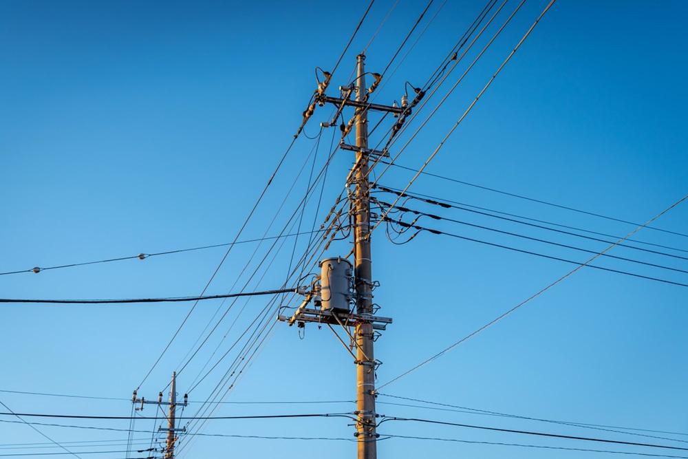 A utility pole in the USA supporting wires for electrical power distribution, coaxial cable for cable television, telephone cable, and fiber cables. PHOTO: shutterstock