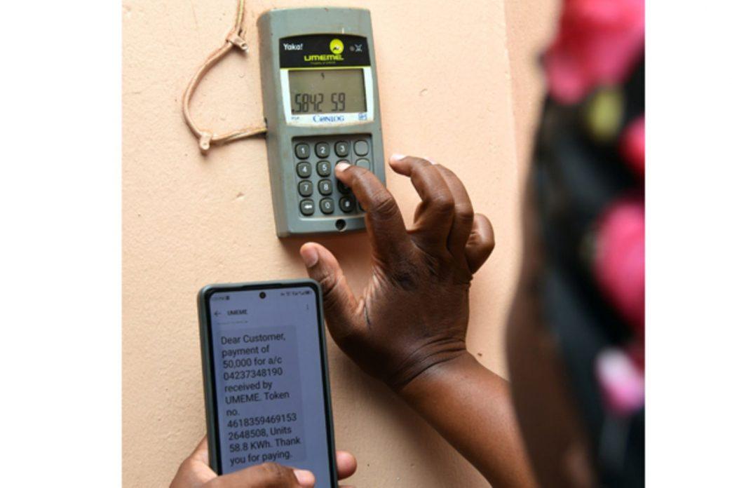 A woman loads yaka units on a yaka meter. PHOTO | FRANK BAGUMA.
