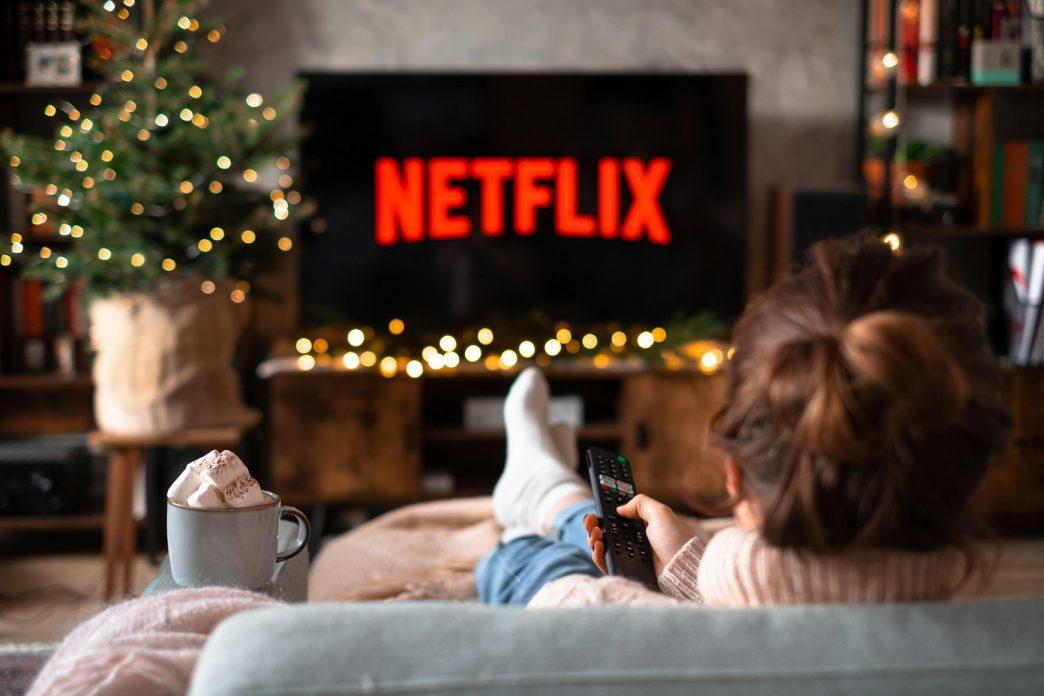 A person seated infront of a TV showing Netflix. COURTESY IMAGE.