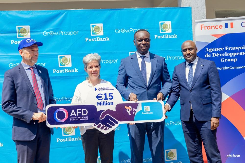 (L-R): Marc Trouyet; Country Director for AFD in Uganda, H.E. Virginie Leroy (C), Ambassador of France to Uganda, Julius Kakeeto; PostBank Uganda Managing Director, and Martin Mugisha; PostBank Uganda Executive Director of Operations, pose for a group photo while holding a pluck card symbolizing the partnership between AFD and PostBank. COURTESY PHOTO
