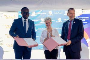 PostBank Uganda Managing Director, Julius Kakeeto (left) and Marc Trouyet, the Country Director for AFD in Uganda exchange MoUs as H.E. Virginie Leroy (C), Ambassador of France to Uganda looks, after they announced their partnership. COURSTESY PHOTO