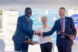 PostBank Uganda Managing Director, Julius Kakeeto (left) and Marc Trouyet, the Country Director for AFD in Uganda shake hands as H.E. Virginie Leroy (C), Ambassador of France to Uganda looks, after they announced their partnership. COURSTESY PHOTO
