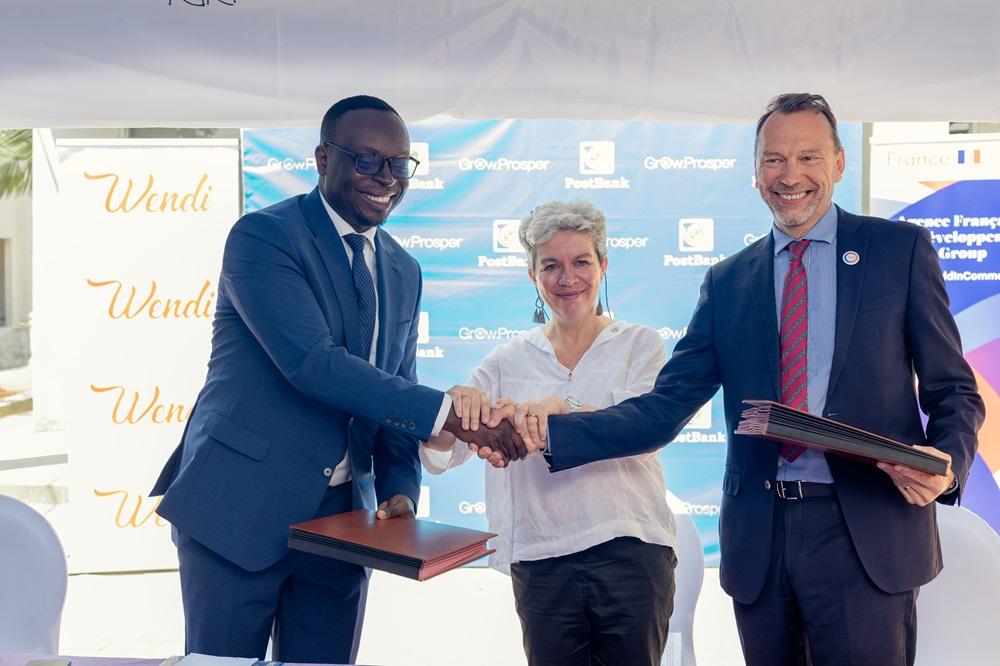 PostBank Uganda Managing Director, Julius Kakeeto (left) and Marc Trouyet, the Country Director for AFD in Uganda shake hands as H.E. Virginie Leroy (C), Ambassador of France to Uganda looks, after they announced their partnership. COURSTESY PHOTO