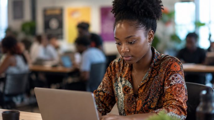 A young woman working on her laptop. IMAGE: AI-Generated