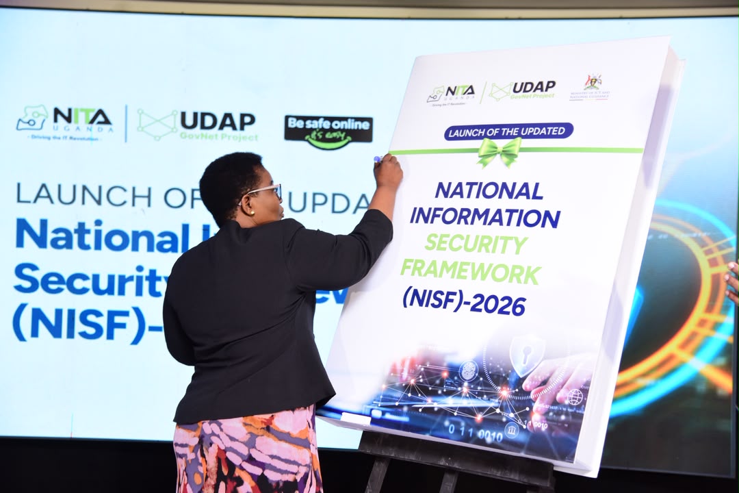 Rt. Hon. Justine Kasule Lumumba, Minister of ICT and National Guidance, signs on a board signaling the launch of the updated National Information Security Framework (NISF) 2026. COURTESY PHOTO
