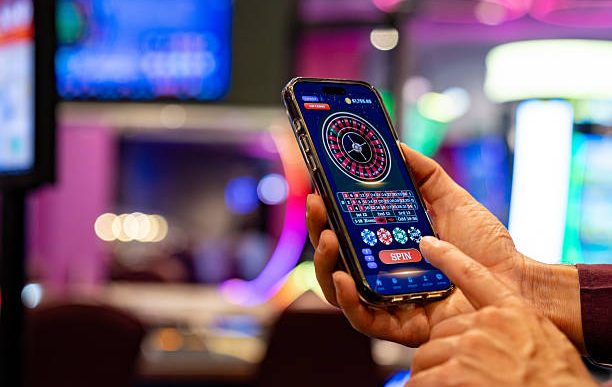 Close-up on a man playing the roulette on a cell phone at a casino - gambling concepts. COURTESY IMAGE