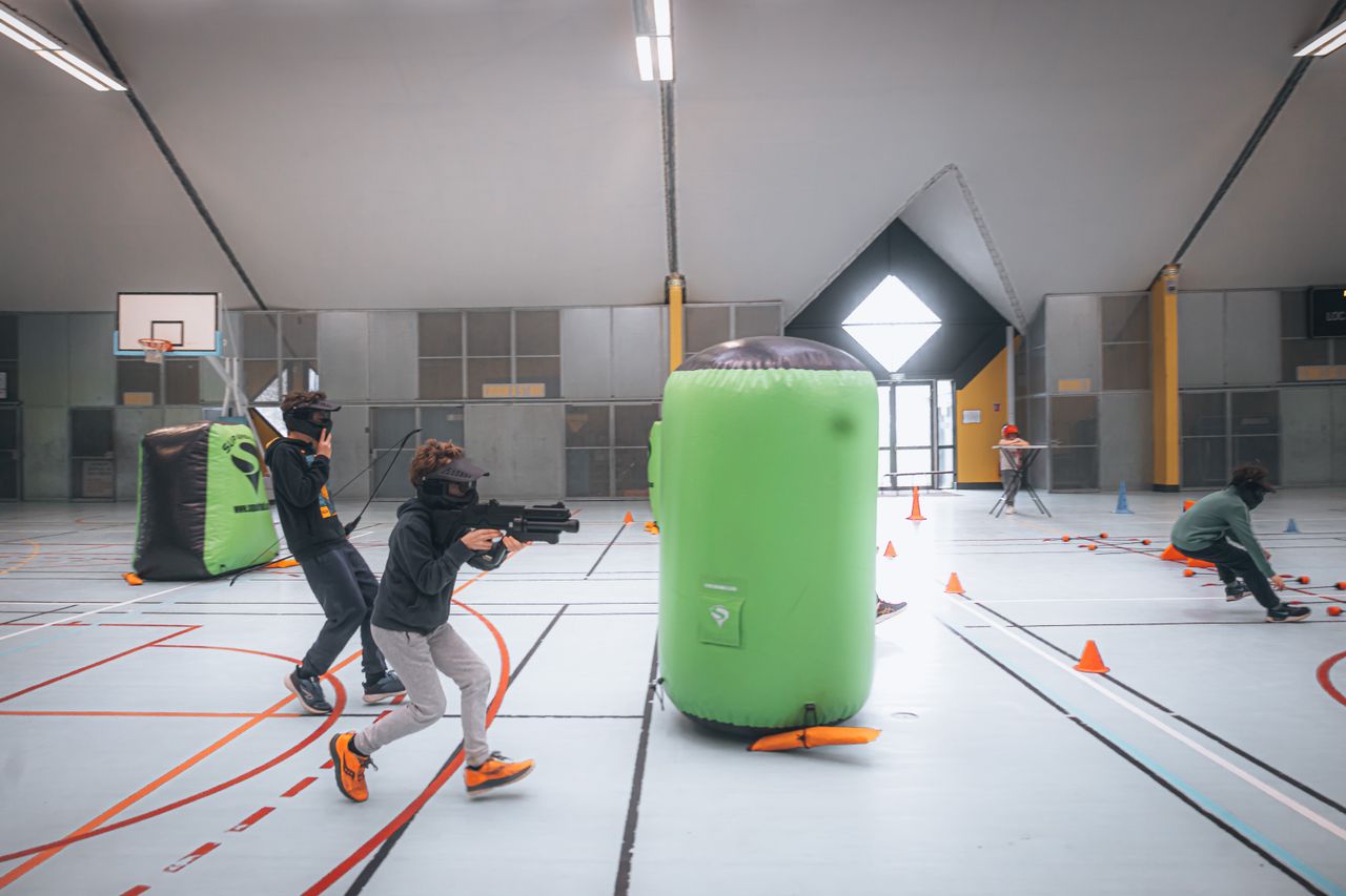 Energetic teenagers playing an indoor laser tag game with vibrant inflatables and obstacles. PHOTO: Newman Photographs/via Pexels